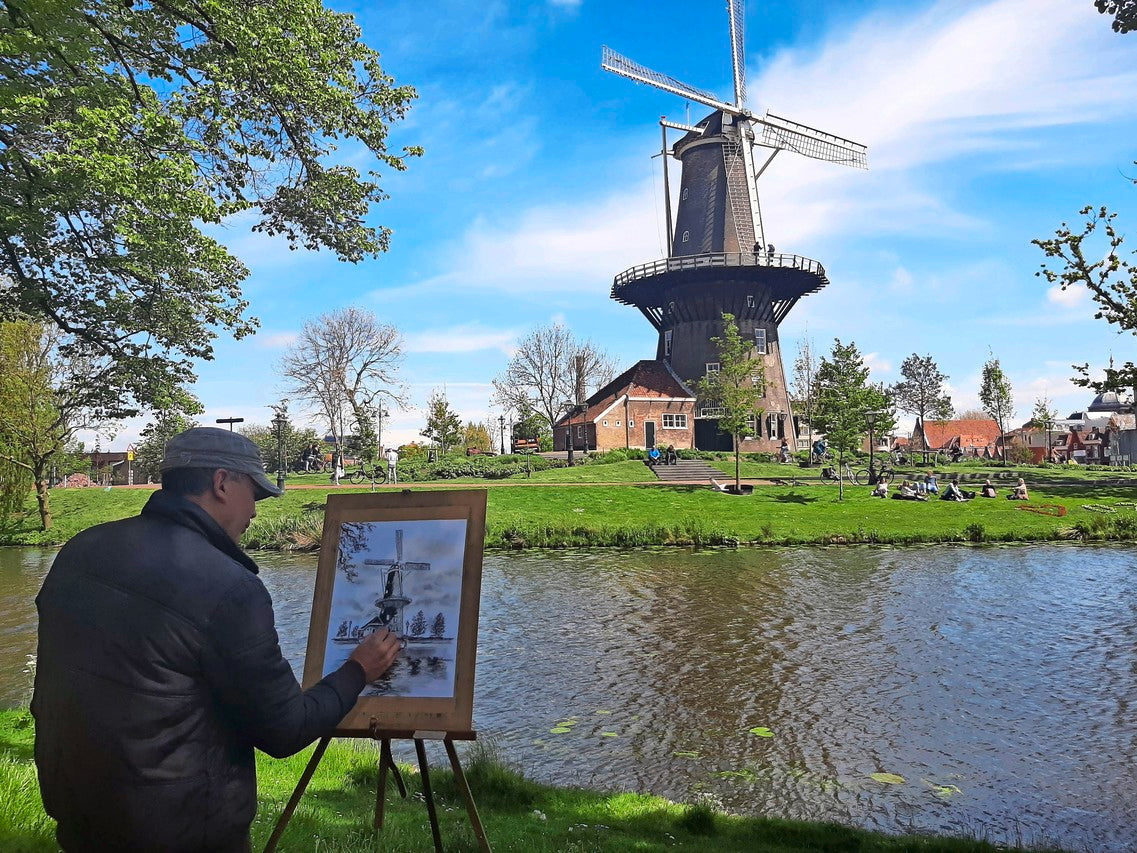 Pablo Artemundo drawing outdoors beside a Dutch windmill